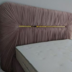 Upholstered bed with pleated tall headboard and gold accent – ReNew Studio