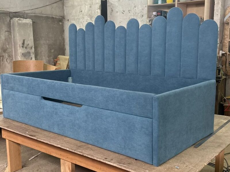 Blue upholstered bed with scalloped tall headboard and storage drawer – ReNew Studio