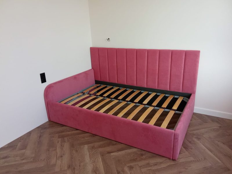 Pink upholstered bed with lifting storage mechanism