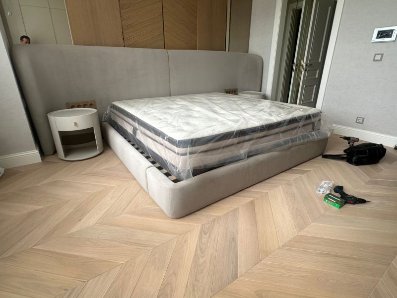 Light gray upholstered bed with tall headboard – ReNew Studio