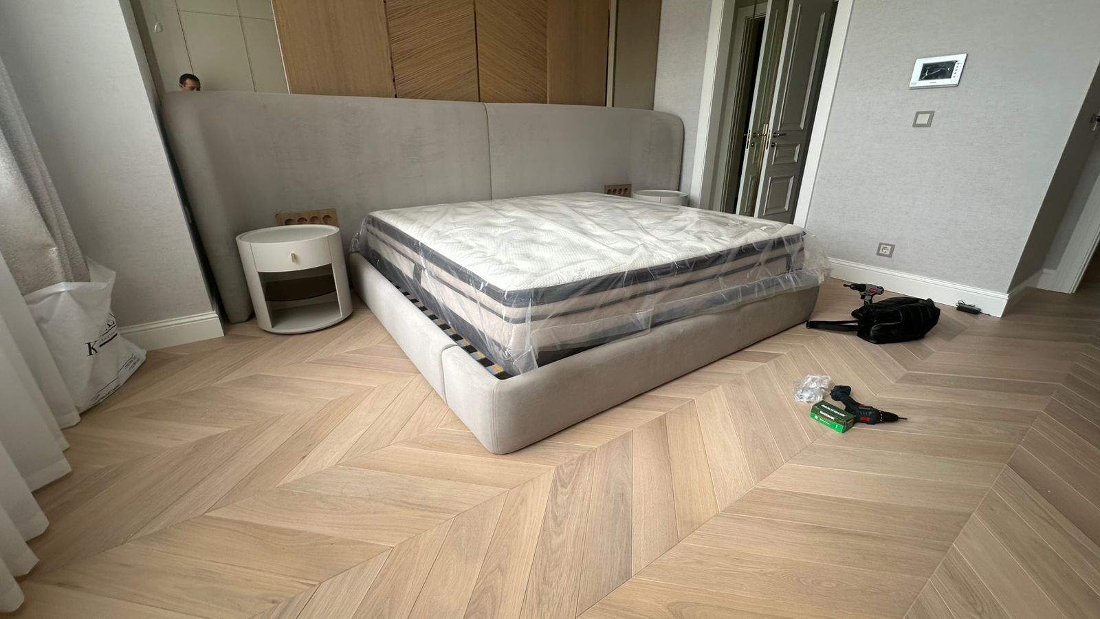 Light gray upholstered bed with tall headboard – ReNew Studio