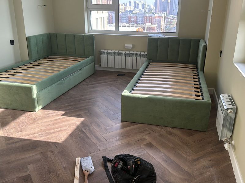 Green upholstered twin beds with corner headboards – ReNew Studio